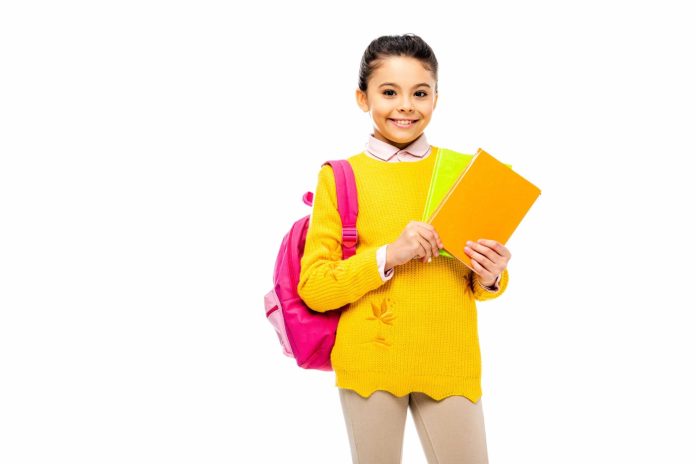 Menina segurando material escolar