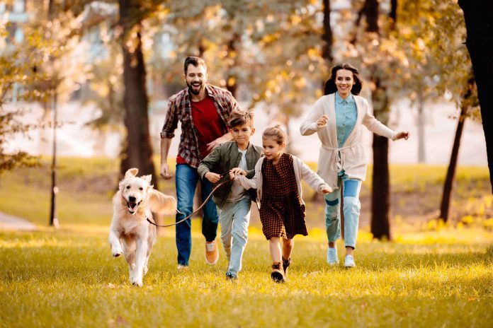 Família com cachorro correndo em parque